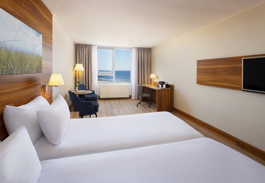 NH Zandvoort Rooms Standard Seaview Twin Bed Blue Chairs Curtains Open Flowers Desk Coffee Machine TV