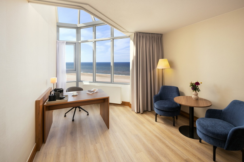 NH_Zandvoort_Rooms_Superior_Seaview_Desk_Coffee_Machine_Flowers_Book_Blue_Chairs.jpg